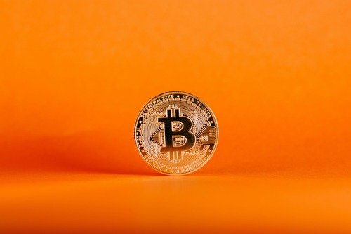 Gold Bitcoin coin standing upright, representing on-chain transaction fee context