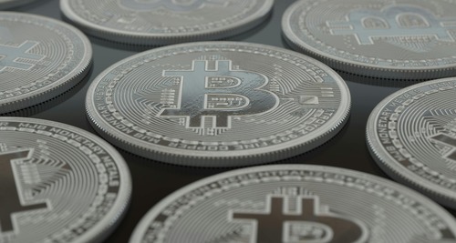 Close-up of plain silver Bitcoin coins representing pseudonymous transactions